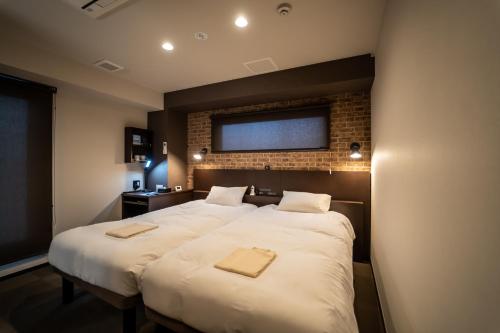 Łóżko lub łóżka w pokoju w obiekcie HOTEL TABARD TOKYO