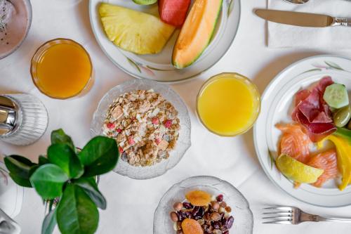 a table with plates of food and bowls of fruit at Hotel Nevada in Samnaun