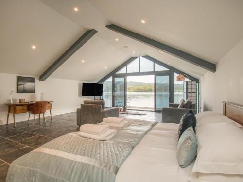 a bedroom with a large bed and a living room at Boathouse on the Lake in Windermere