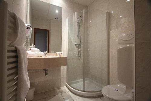 La salle de bains est pourvue d'une douche, d'un lavabo et de toilettes. dans l'établissement Kyriad Hotel Lamballe, à Lamballe