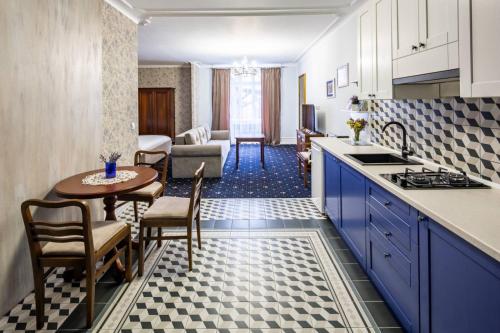 a kitchen with blue cabinets and a table and a living room at Руська, 4 in Lviv