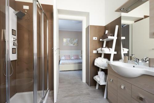 a bathroom with a shower and a sink and a bed at Camere Santa Rita in Negrar