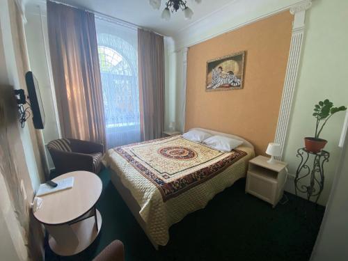 a small hotel room with a bed and a table at Hotel ALTEYA in Moscow