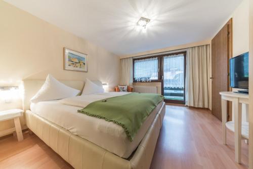 a bedroom with a large bed and a television at Gästehaus Brugger Martin in Sölden
