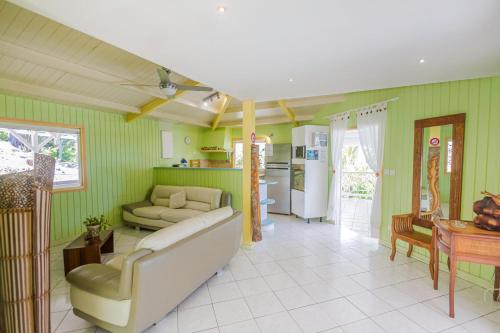 a living room with green walls and a couch at GREEN HOUSE in Deshaies