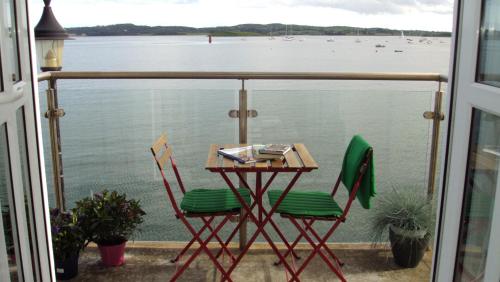 a table and chairs on a balcony with a view of the water at Rock Quay in Killyleagh