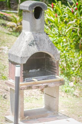 a stone pizza oven sitting in a yard at GREEN HOUSE in Deshaies