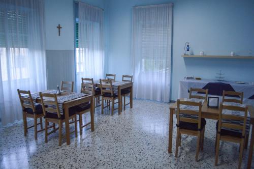 a dining room with tables and chairs and a cross on the wall at La fontana de li Papi in Cava deʼ Tirreni