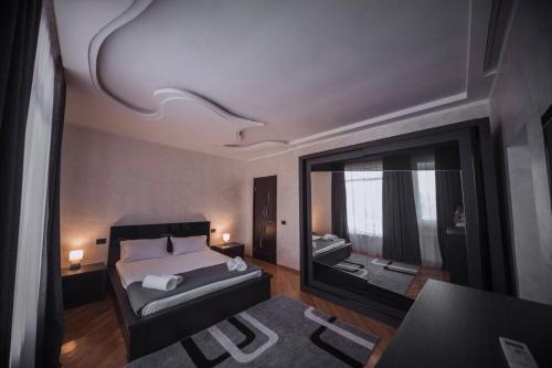 - une chambre avec un lit et un grand miroir dans l'établissement Makos Guest House, à Koutaïssi