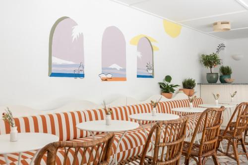 a restaurant with tables and chairs and windows at Hôtel Le Sud in Juan-les-Pins