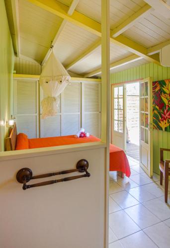 a bedroom with an orange bed in a room at GREEN HOUSE in Deshaies
