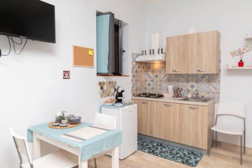 a kitchen with a table and a small kitchen with a sink at Civico 87 in Benevento