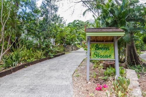a sign for a flower house next to a walkway at GREEN HOUSE in Deshaies