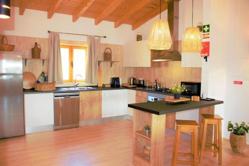 a kitchen with white cabinets and a black counter top at Quinta das Alfambras in Aljezur