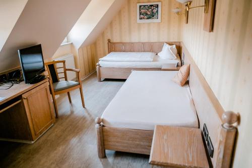 a small room with two beds and a television at Landhaus Bisping in Everswinkel