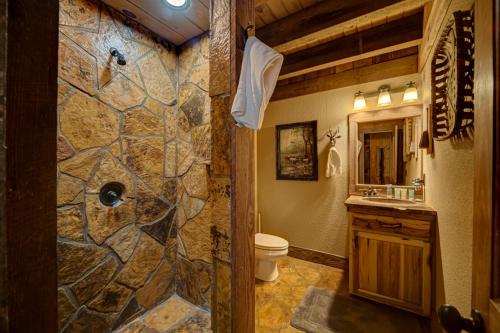 a stone bathroom with a toilet and a sink at Winding Log Ridge in Blue Ridge