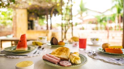 uma mesa com pratos de comida por cima em Kanaloa Pousada em Jericoacoara