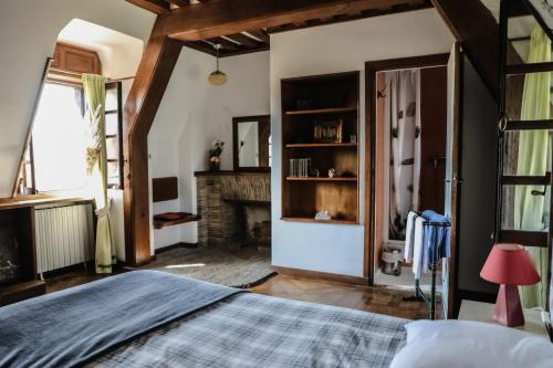 a bedroom with a bed and a fireplace at Le Logis d'Arniere in Saint Cyr-sous-Dourdan