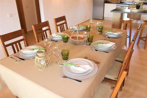 a table with plates and wine glasses on it at Quinta das Alfambras in Aljezur