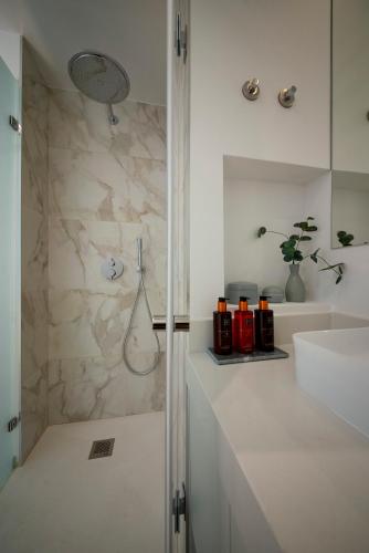 a white bathroom with a shower and a sink at Chiado Oasis with Private Garden by NestAtLisbon in Lisbon
