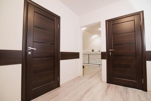 two wooden doors in a room with wooden floors at Margit Sziget in Svalyava