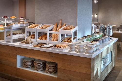 a bakery counter with various types of pastries at Holiday Inn & Suites - Dubai Festival City by IHG in Dubai