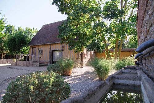 a house with a garden and a building at Le Jardin Découverte in Conches-en-Ouche