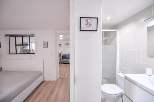 a white bathroom with a bed and a sink at 2 pièces indépendant dans maison familiale - One bedroom apartment - Family friendly in Vitry-sur-Seine