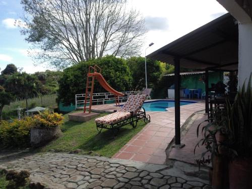 un patio con un banco y un tobogán junto a una piscina en Villa Kyra, en Calima