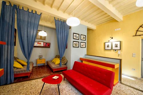 a living room with a red couch and blue curtains at Spacious Apartment with City View in Foiano della Chiana 125 m² in Foiano della Chiana
