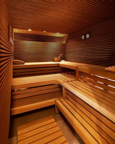 a sauna with wooden benches in a room at Fuchsbau Romantik Hotel & SPA Restaurant & FOX Bar in Timmendorfer Strand