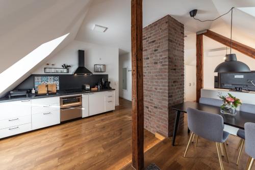 uma cozinha com armários brancos e uma parede de tijolos em Design-Loft und Apartment im Villenviertel em Mülheim an der Ruhr