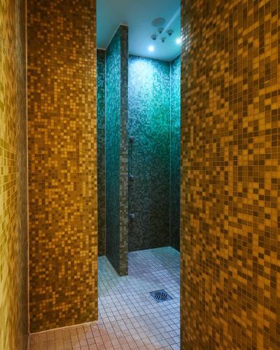 a bathroom with a shower with a brick wall at Fuchsbau Romantik Hotel & SPA Restaurant & FOX Bar in Timmendorfer Strand