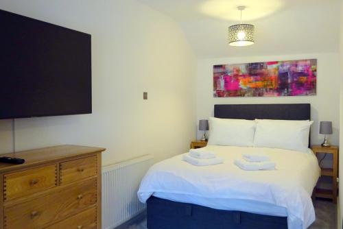 a bedroom with a bed with a flat screen tv at Derwent View Holiday Apartments in Matlock