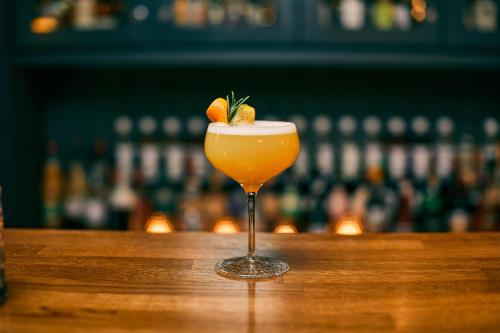 a drink sitting on a bar with aigger in it at Fuchsbau Romantik Hotel & SPA Restaurant & FOX Bar in Timmendorfer Strand