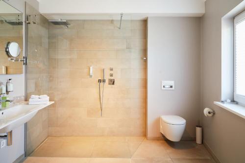 a bathroom with a shower with a toilet and a sink at Fuchsbau Romantik Hotel & SPA Restaurant & FOX Bar in Timmendorfer Strand