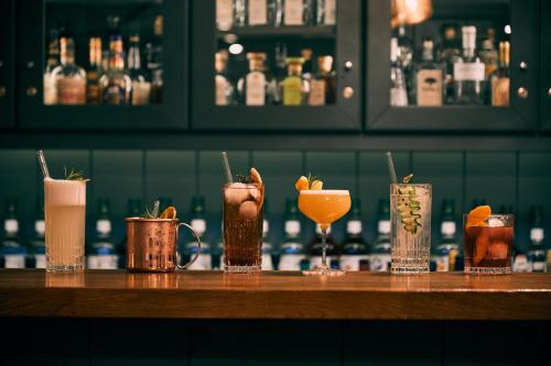 a group of different cocktails sitting on a bar at Fuchsbau Romantik Hotel & SPA Restaurant & FOX Bar in Timmendorfer Strand
