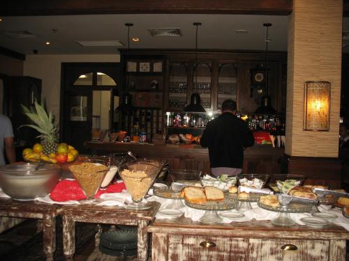 a man standing in a kitchen with a buffet of food at Flat em Gramado in Gramado