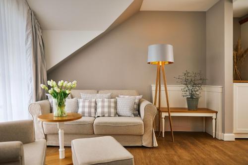 a living room with a couch and a table at Fuchsbau Romantik Hotel & SPA Restaurant & FOX Bar in Timmendorfer Strand