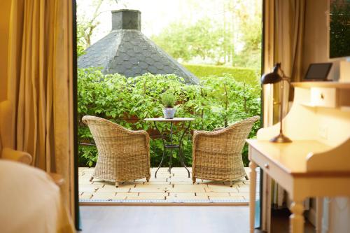 a patio with a table and chairs on a porch at Fuchsbau Romantik Hotel & SPA Restaurant & FOX Bar in Timmendorfer Strand