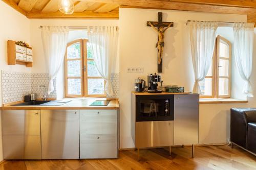 a kitchen with a counter and a refrigerator and windows at Apartments No 126 Loket in Loket