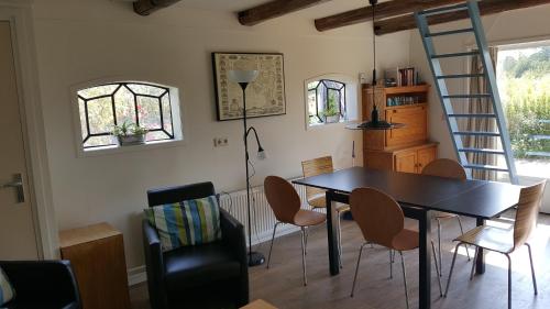 a dining room with a table and chairs and a ladder at Villa Selva in Loppersum