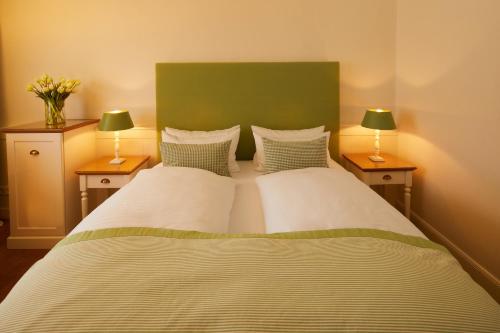 a bedroom with two beds with two lamps on both sides at Fuchsbau Romantik Hotel & SPA Restaurant & FOX Bar in Timmendorfer Strand