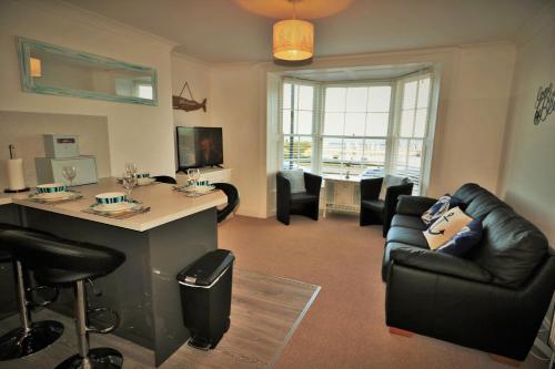 a living room with a black leather couch and an island at Cultural heart of Margate in Margate
