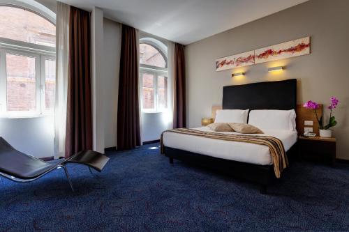 a hotel room with a bed and a chair at Hotel Rinascimento - Gruppo Trevi Hotels in Rome