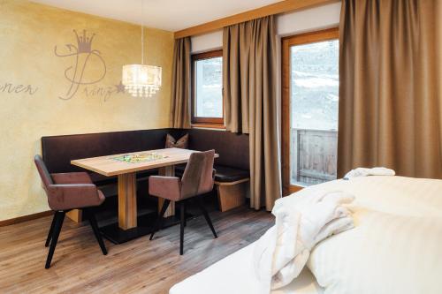 a hotel room with a bed and a table and chairs at Kinderhotel Laderhof in Ladis