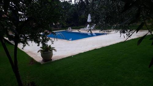a swimming pool in a yard with a green lawn at MEDITERRANEAN GARDEN VILLA in Vathí