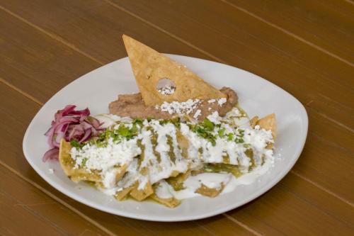 een witte plaat met eten op een houten tafel bij Hotel Santa Rita in Guanajuato