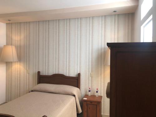 a small bedroom with a bed and a window at Hotel Santa Rosa in Cholula