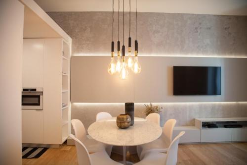 a dining room with a table and chairs and a tv at FLH Augusta's Arch Sophisticated Flat in Lisbon